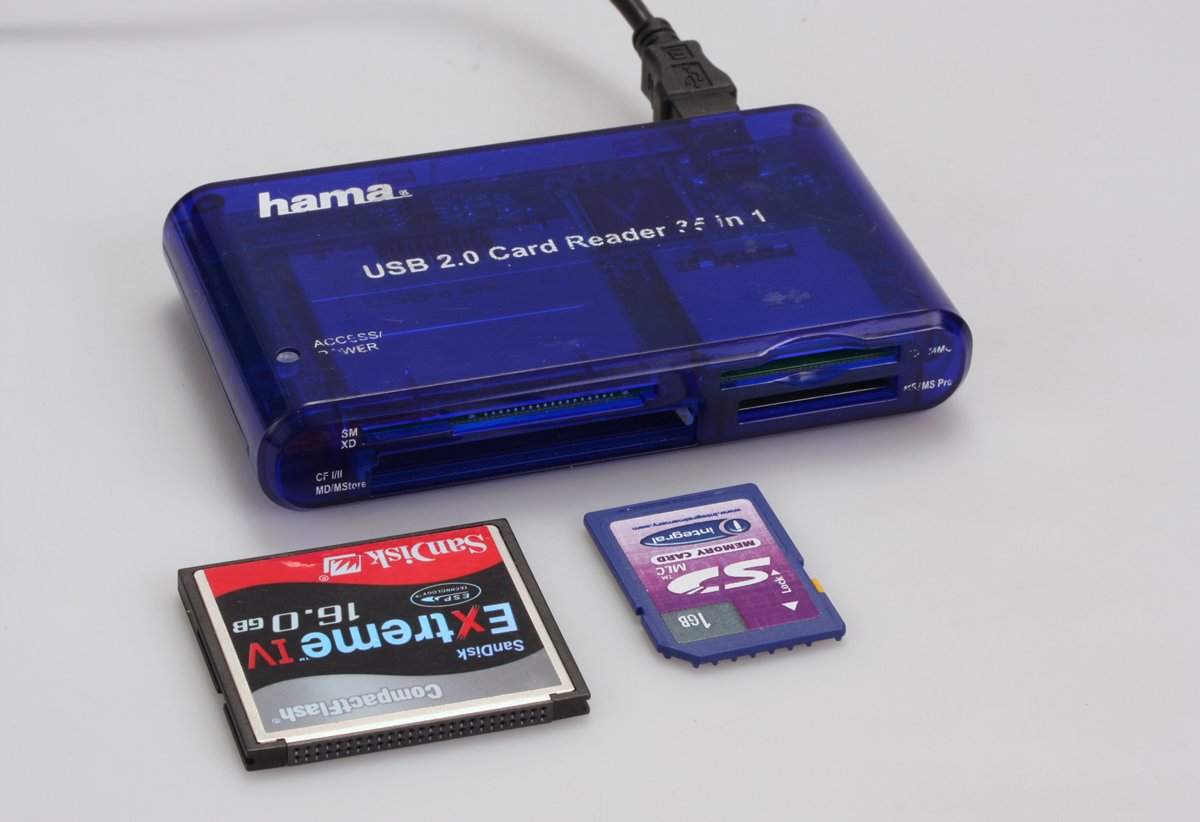 Twee typen kaarten (SD en CompactFlash) waar foto’s op weggeschreven worden, plus een universele kaartlezer om foto’s over te zetten op een computer.